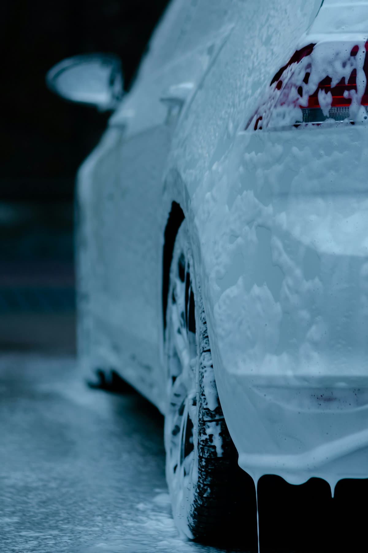 Car covered in white cleaning foam during a wash